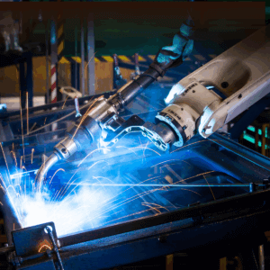 Robotic welding arm performing precision metal fabrication with bright sparks in a manufacturing facility